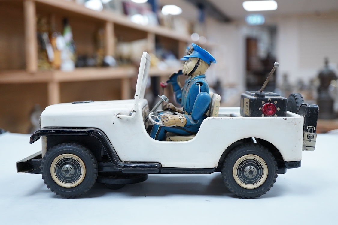 A 1960s Japanese T.N. Nomura battery powered tinplate and plastic Police Department Jeep, impressed manufacturer’s logo and ‘Made in Japan’ to the base